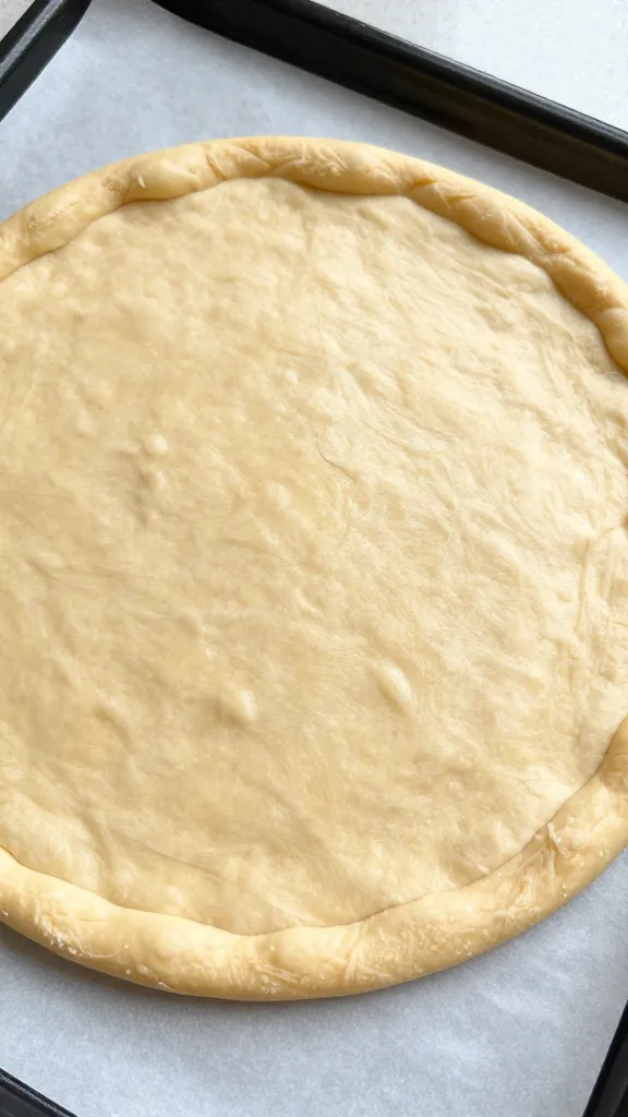 Gluten-free pizza crust on parchment, light and crispy